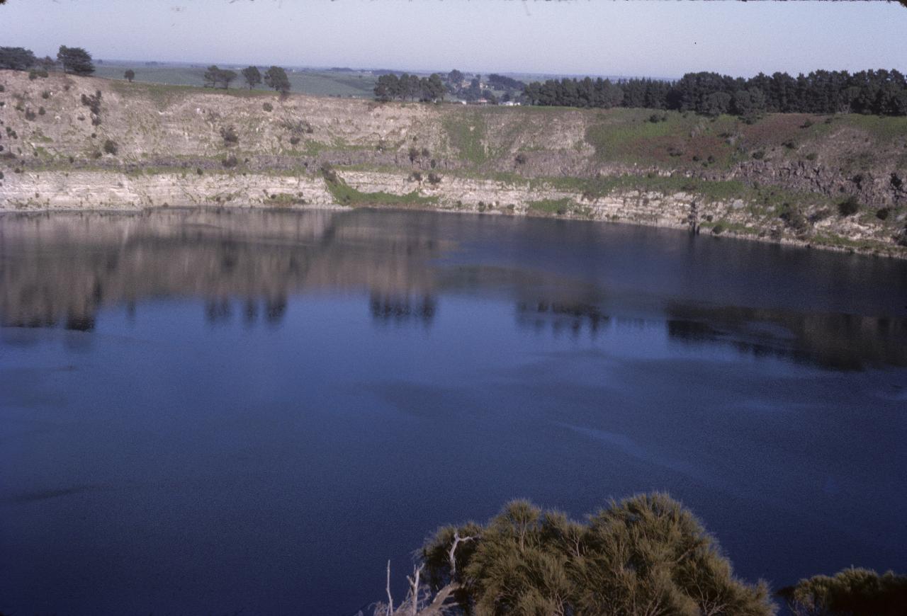 Volcanic crater, roughly circular, with blue water