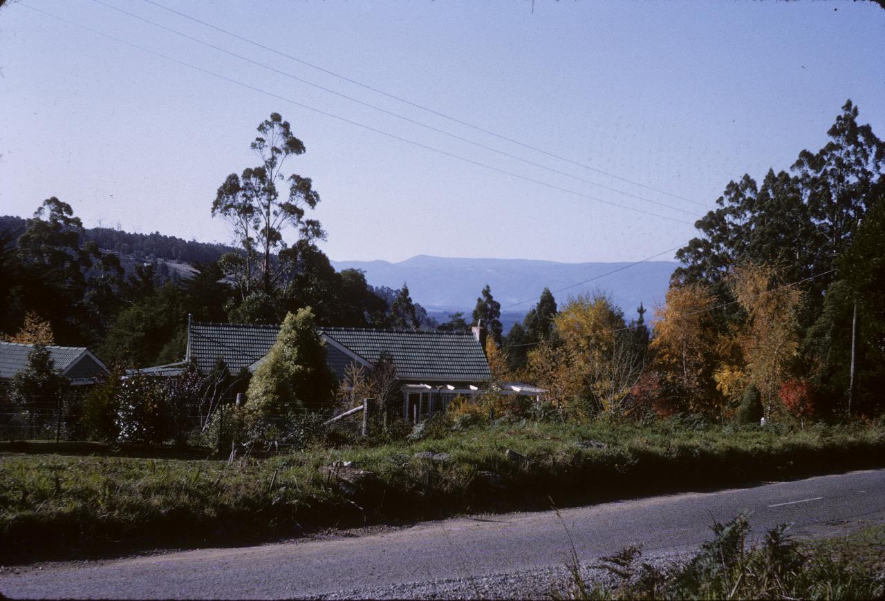 House with autumn trees across to distant blue hills