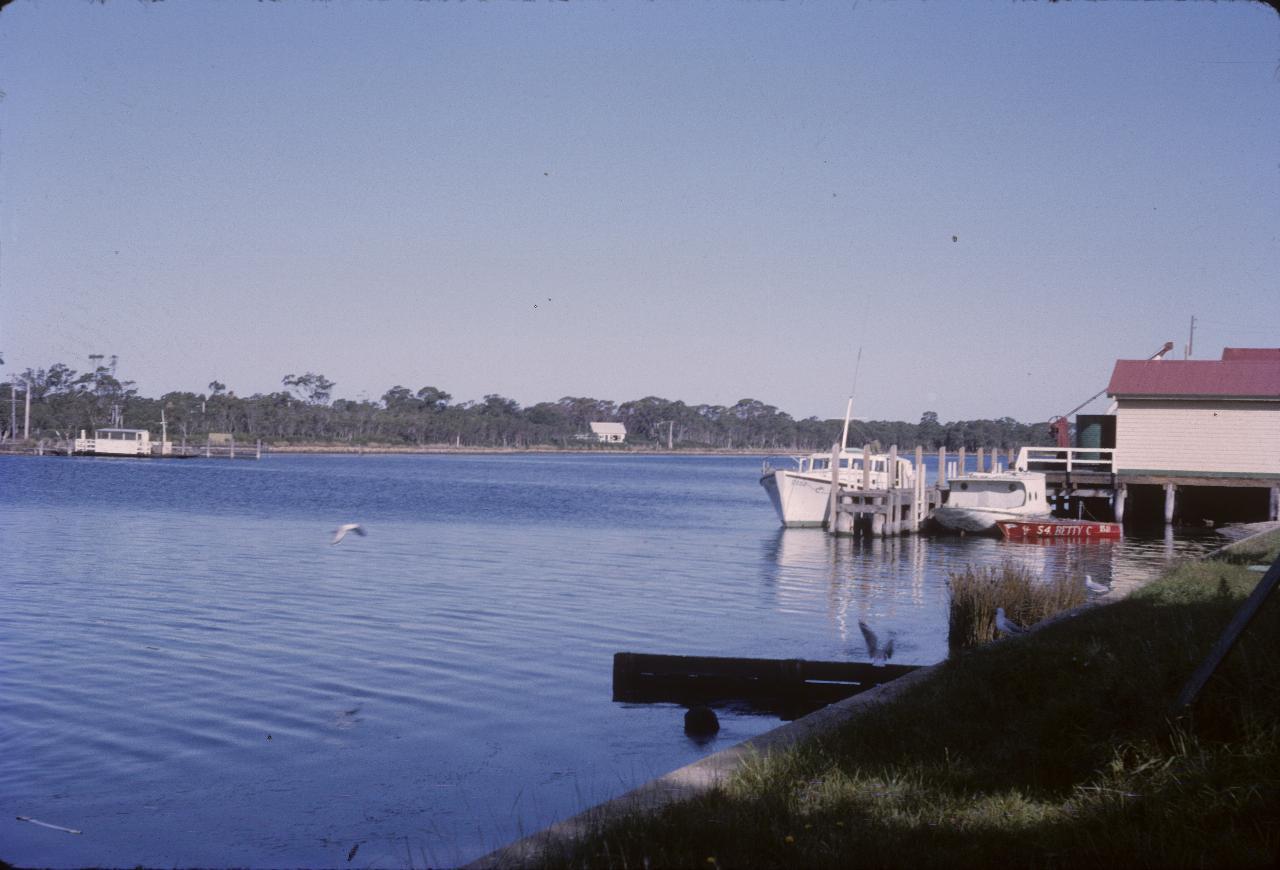 Waterway with boat shed and a couple of boats tied up