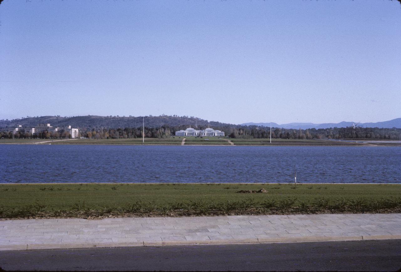 View across lake to white building and hill behind.