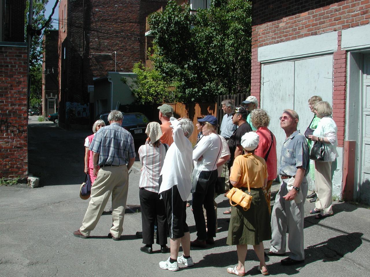 KPLU tour group examing the back allies of suburban Montreal