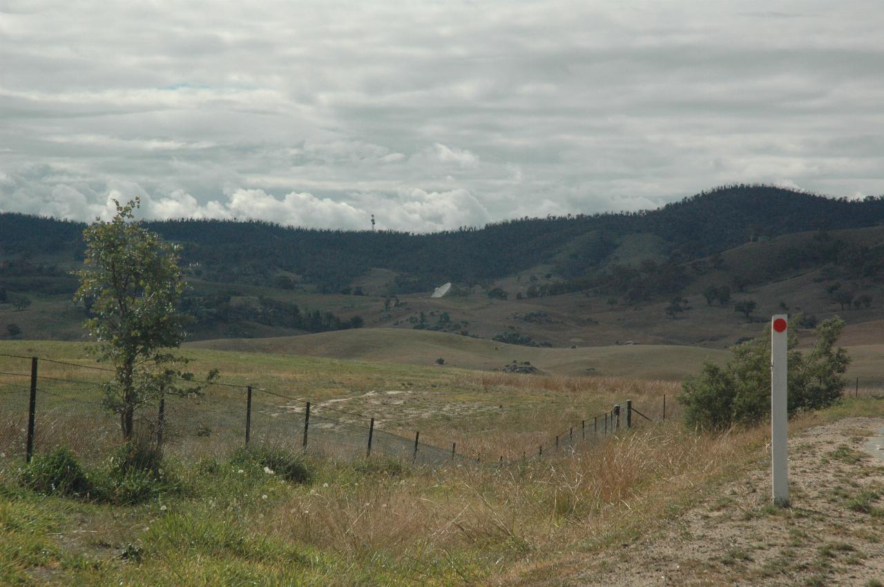 Bush scene, mountains in background, top of tracking dish just visible