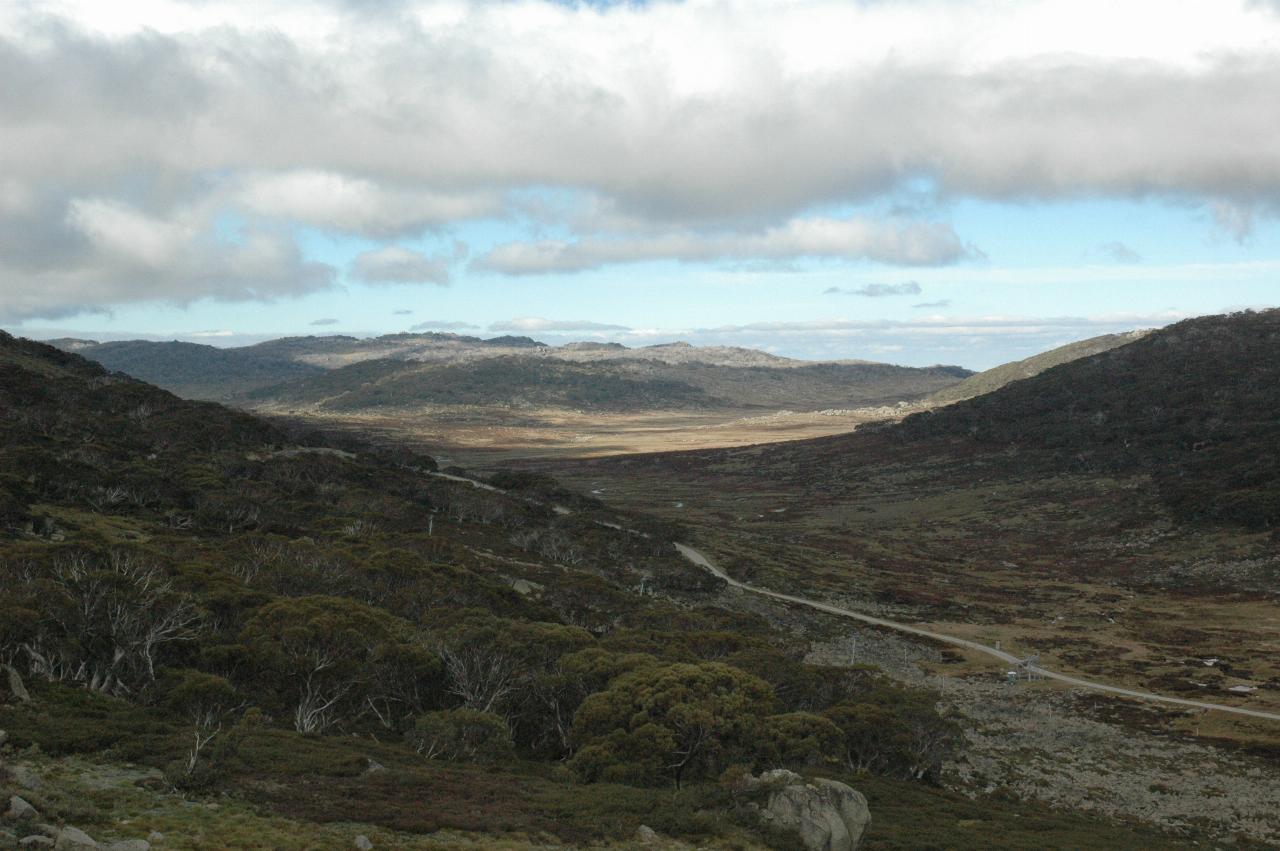 Shallow valley with dirt road, distant mountains