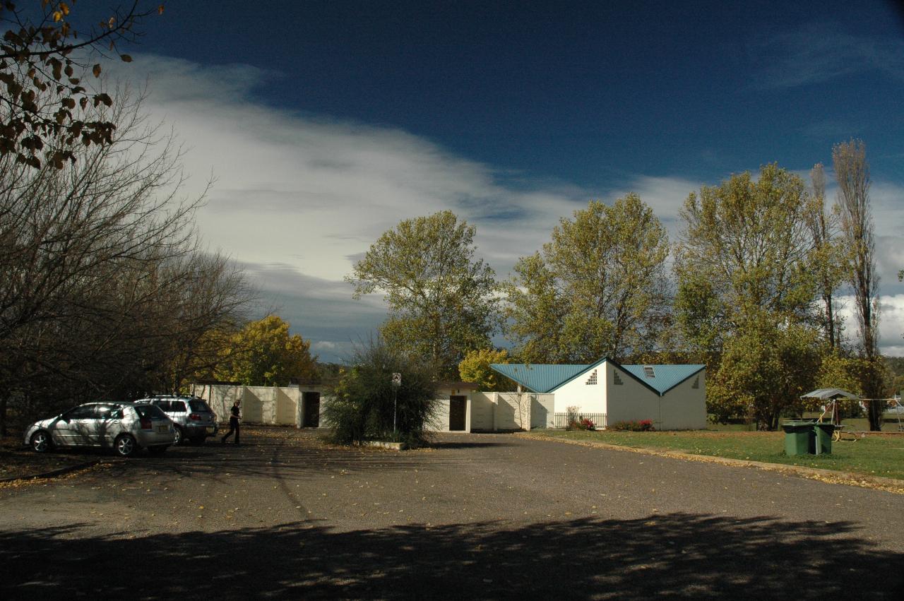 Cream and green building, trees with autumn colour in park