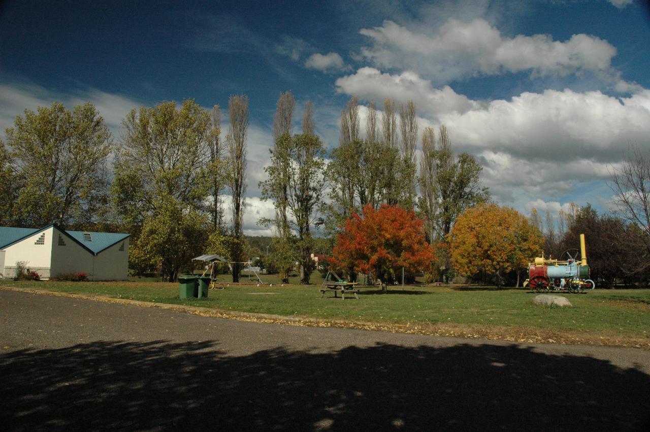Cream and green building, trees with autumn colour in park